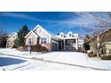 Charming two-story home with manicured landscaping, brick accents, gray siding, and a two-car garage at 8387 Fig St, Arvada, CO 80005