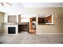 Spacious living room with a fireplace, large window, and seamless view into the kitchen at 8387 Fig St, Arvada, CO 80005