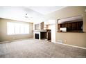 Spacious living room with a fireplace, large window, and seamless view into the kitchen at 8387 Fig St, Arvada, CO 80005