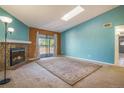 Spacious living room with a fireplace, skylight, and balcony access, creating a bright and inviting atmosphere at 904 S Walden Way # 203, Aurora, CO 80017