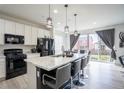 Modern kitchen features a large island with seating and stainless steel appliances at 26985 E Bayaud Ave, Aurora, CO 80018