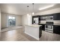 Modern kitchen with stainless steel appliances, granite countertops, and an island overlooking the living area at 4100 Albion St # 523, Denver, CO 80216