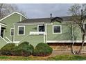 Charming green home featuring well-maintained landscaping and a welcoming entrance at 4108 S Rifle Way, Aurora, CO 80013