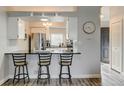 Kitchen view with breakfast bar and stainless steel refrigerator at 4108 S Rifle Way, Aurora, CO 80013