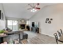 Relaxing living room featuring a vaulted ceiling and a stone fireplace at 4108 S Rifle Way, Aurora, CO 80013