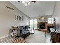 Inviting living room featuring a stone fireplace and access to the outdoor balcony at 4108 S Rifle Way, Aurora, CO 80013