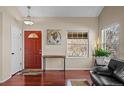 Bright entryway with hardwood floors, a vibrant red door and natural light at 1271 Berganot Trl, Castle Pines, CO 80108
