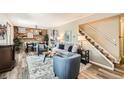 Cozy living room featuring a decorative brick wall, stairs to the second floor, and an open floor plan at 10457 Owens Cir, Broomfield, CO 80021