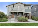 Inviting two-story home featuring a spacious porch, balcony, and a well-maintained landscaped front yard at 8464 E 55Th Pl, Denver, CO 80238