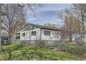 Exterior view of house with a chain link fence and a large backyard featuring plenty of space at 925 Quitman St, Denver, CO 80204
