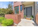 Close up of the home's brick entrance, featuring a modern front door and vibrant flower planters at 1833 E Jewell Ave, Denver, CO 80210