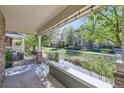 Inviting covered patio with decorative string lights offers a tranquil view of the neighborhood's landscaped grounds at 17244 E Kansas Dr, Aurora, CO 80017
