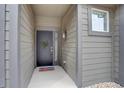 Inviting front entry with a decorated door, modern wall light, and welcoming doormat at 11568 Dewey St, Parker, CO 80138