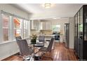 Bright kitchen features stainless steel appliances, granite countertops, and adjacent dining area with hardwood floors at 3336 W 35Th Ave, Denver, CO 80211
