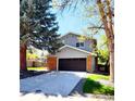 Inviting two-story home with a spacious driveway, brick accents, and an attached two-car garage at 6521 Zinnia St, Arvada, CO 80004