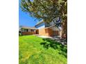 Charming two-story home featuring a brick facade, well-maintained lawn, and mature shade tree at 6521 Zinnia St, Arvada, CO 80004