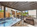 Inviting covered patio with hot tub, fireplace, comfortable seating and a large outdoor television for entertaining at 15547 W Vassar Ave, Lakewood, CO 80228