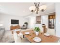 Cozy living room featuring a dining table, a chair, a TV, and a view into the kitchen at 5888 Biscay St # D, Denver, CO 80249