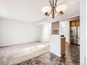 View of open-concept living room leading into kitchen with stainless steel appliances at 5888 Biscay St # D, Denver, CO 80249