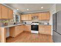 Bright kitchen with stainless steel appliances, granite countertops, tiled backsplash, and wood cabinets at 21455 E 44Th Ave, Denver, CO 80249