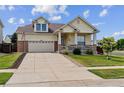 Inviting two-story home with a cozy front porch, green lawn, and a spacious driveway leading to a two-car garage at 4293 Clover Ln, Brighton, CO 80601