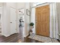 Welcoming foyer features hardwood floors, a charming rug, and a view into a workout room at 4293 Clover Ln, Brighton, CO 80601