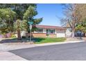 A charming single-story home with mature trees and a well-manicured lawn at 3195 S Kalispell Ct, Aurora, CO 80013