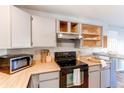 Functional kitchen with sleek black appliances, wood countertops, and ample storage space at 4246 S Eldridge St # 103, Morrison, CO 80465