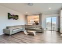 Open living room with gray sectional sofa and kitchen view at 6938 S Riverwood Way, Aurora, CO 80016