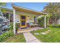 Inviting front porch with seating, decorative lights, and a well-maintained garden and brickwork at 1292 Kearney St, Denver, CO 80220