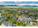 Expansive aerial view showcasing a suburban neighborhood with mountain views, lush greenery, and residential properties at 2822 Flint Ct, Superior, CO 80027