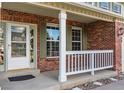 Inviting front porch detail with brick accents, white railing, and a classic entrance door at 2822 Flint Ct, Superior, CO 80027