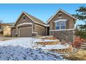 Charming two-story home with stone accents, a three-car garage, and landscaped front yard at 461 Saber Creek Dr, Monument, CO 80132