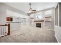 Spacious living room with a fireplace, large windows, and neutral carpeting at 461 Saber Creek Dr, Monument, CO 80132