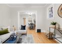 Well-lit living room boasts hardwood floors, modern decor, and an open view to the dining room at 4893 Newton St, Denver, CO 80221