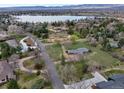Aerial view of a home featuring mature trees and established landscaping near a serene lake with mountain views at 4901 Redwood Dr, Littleton, CO 80123
