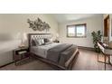 Serene bedroom showcases a comfortable bed with stylish lamps and a tranquil view through the window at 23566 Pondview Pl # F, Golden, CO 80401