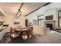 Charming dining area with vaulted ceiling, wood beam, and adjacent fireplace and living room at 23566 Pondview Pl # F, Golden, CO 80401