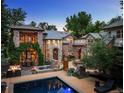 Beautiful stone and brick home with outdoor fire pit, pool, and lush landscaping at 850 E Radcliff Ave, Cherry Hills Village, CO 80113
