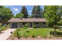 Charming single-story home with a lush green lawn, mature trees, and an attached garage at 3545 Cloverleaf Dr, Boulder, CO 80304