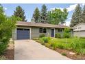 Charming single-story home with a lush green lawn, mature trees, and an attached garage at 3545 Cloverleaf Dr, Boulder, CO 80304