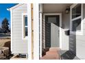 Stylish front entrance with a gray front door, modern lighting, and a convenient bench for visitors at 4920 Clay St, Denver, CO 80221