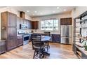 Modern kitchen with stainless steel appliances and breakfast bar table at 8361 Parkland St, Broomfield, CO 80021