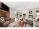 Open-concept living room with a brick fireplace and access to the backyard at 3343 S Monaco Pkwy # A, Denver, CO 80222