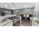 Open concept kitchen with granite countertops, stainless steel appliances, and eat-in dining area at 525 Jackson St # 304, Denver, CO 80206