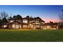 Expansive home exterior showcases large windows and stone accents against a sunset backdrop at 4475 S Downing St, Cherry Hills Village, CO 80113