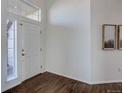 Inviting foyer with gleaming hardwood floors, bright white walls, and natural light from large windows at 22388 Quail Run Dr, Parker, CO 80138