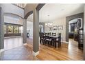 An elegant dining room with a dark wood table, chandelier, and hardwood floors that create a warm ambiance at 3431 Fantasy Pl, Castle Rock, CO 80109