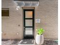 Modern brick house featuring a front door with glass panels, house number 1333, and a potted plant at 1333 Elati St # 1, Denver, CO 80204