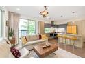Cozy living room and kitchen with a comfortable sofa, modern cabinets, and a large window at 1333 Elati St # 1, Denver, CO 80204